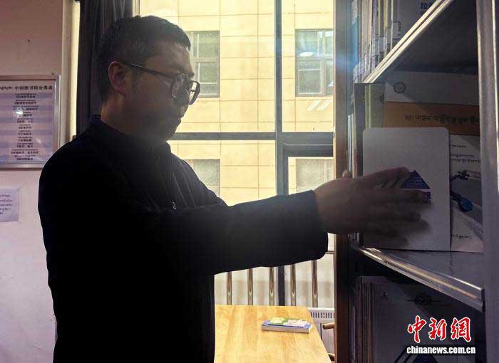 Photo de Lu Kang rangeant les livres papier à la bibliothèque de Lhassa. (Photo d'archive fournie par la bibliothèque de Lhassa)